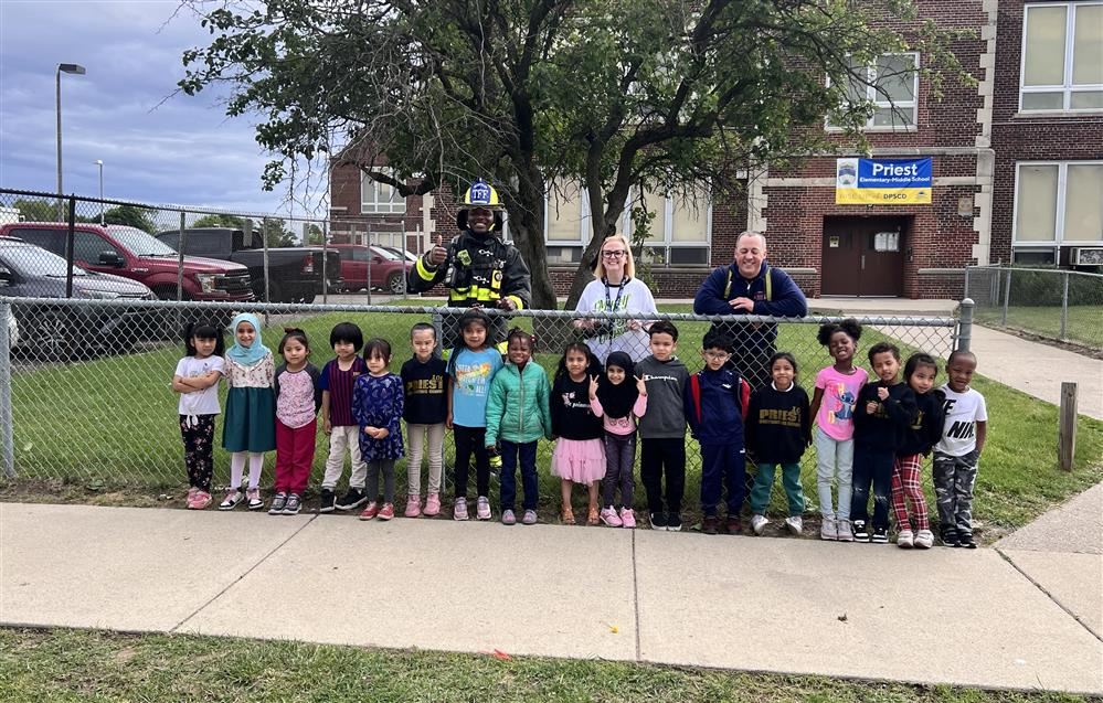  Kindergartners stand with firefighters outside Priest Elementary